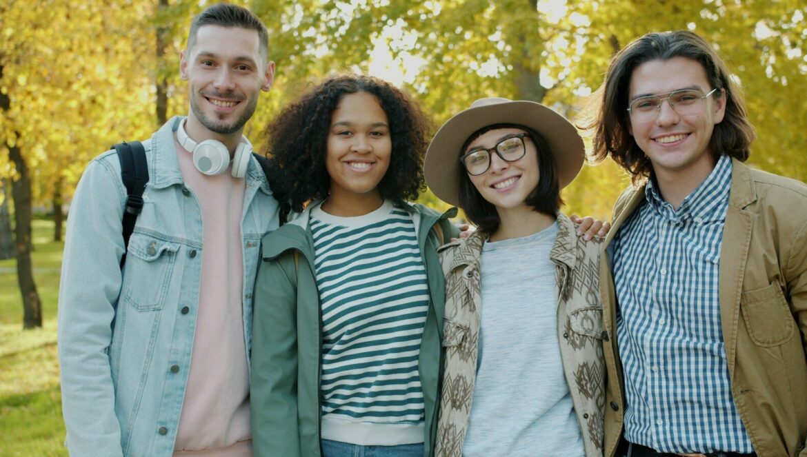 Four friends smiling in a park during autumn | edCircuit Four friends smiling in a park during autumn