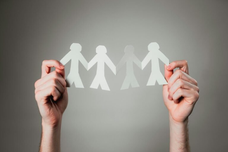 Hands holding paper cutout family chain