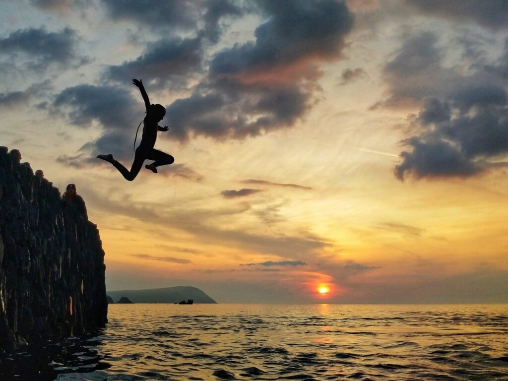 Silhouette of man jumping on sea during sunset | edCircuit Silhouette of man jumping on sea during sunset