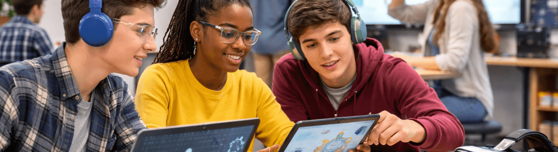 Students collaborate on STEM projects using laptops and tablets in a classroom; EdTech trends are evident with robotics equipment and a VR headset visible on the table.