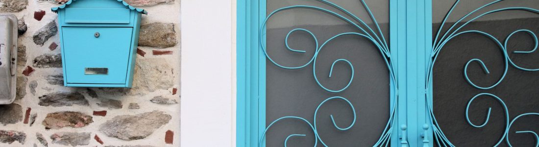 Elegant blue door and vintage mailbox on a stone wall in Kavala, Greec