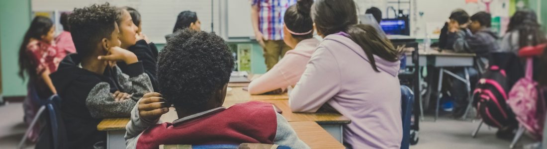 Students in classroom with teacher presenting