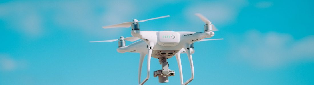 White quadcopter flying during daytime